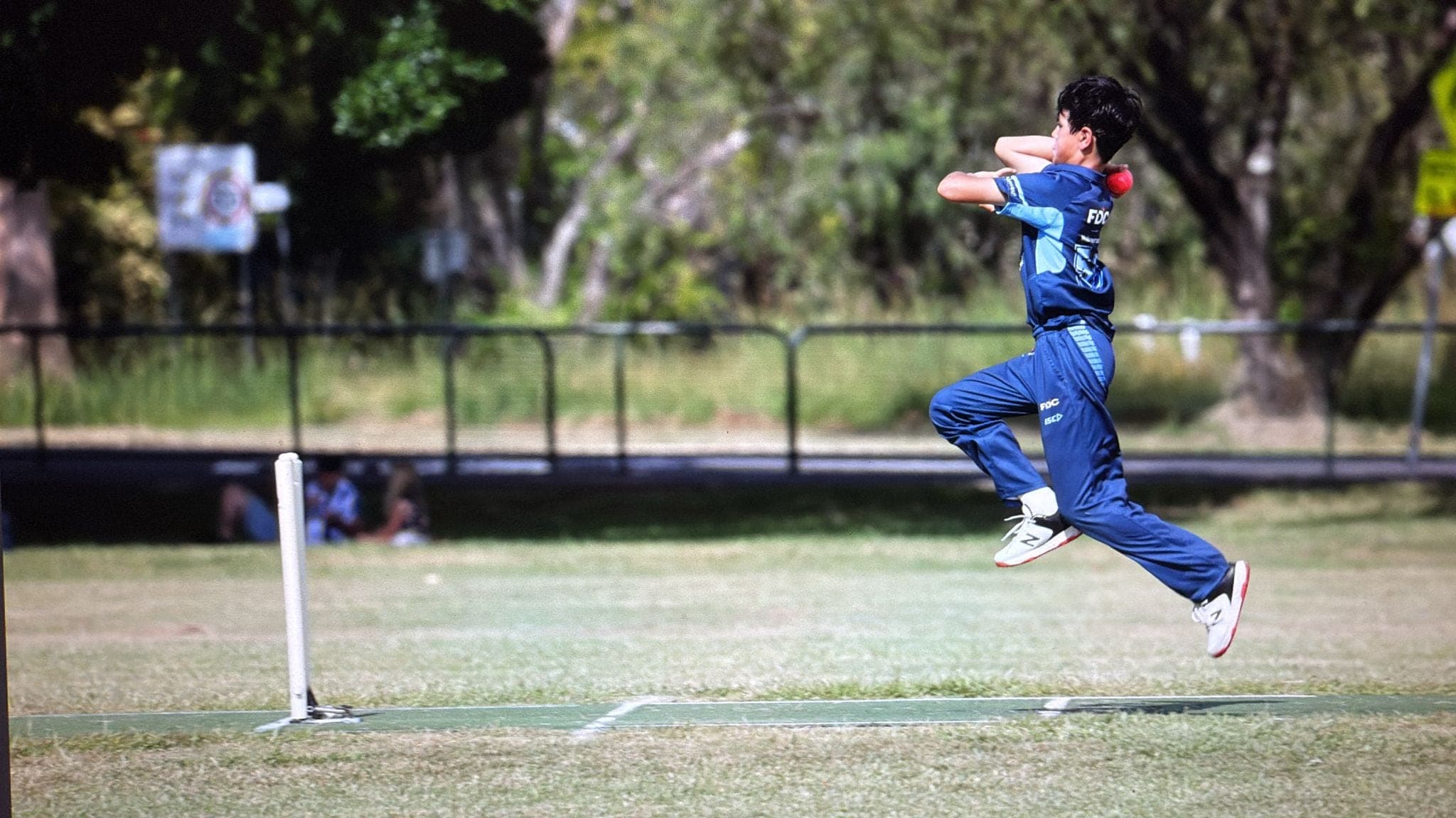 Ethan mid-air in his bowling delivery stride during a Division 1 representative cricket match