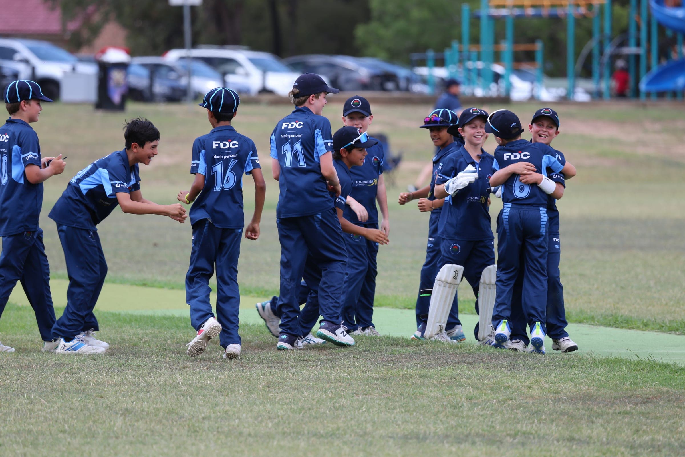 Ethan and his teammates running together to celebrate a wicket
